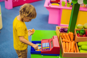 Menino brincando com uma maquina de dinheiro